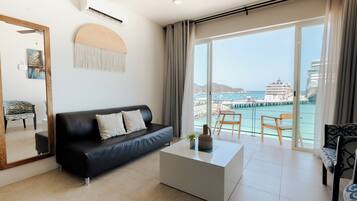 Suite, 2 camas matrimoniales, vista al océano | Área de sala de estar | Smart TV de 32 pulgadas con canales digitales