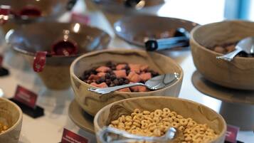 A buffet with various food items in wooden bowls, each labeled with a small sign.
