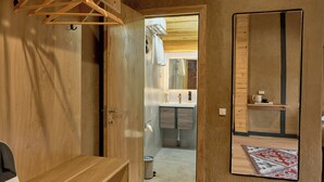 A wooden room with a bench, a hanging rack, and a mirror on the wall. - Pristine Hotel (Bishkek)