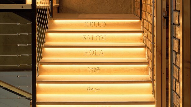 A staircase with steps labeled with greetings in multiple languages. - Pristine Hotel (Bishkek)