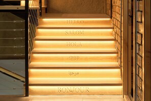 A staircase with steps labeled with greetings in multiple languages. - Pristine Hotel (Bishkek)