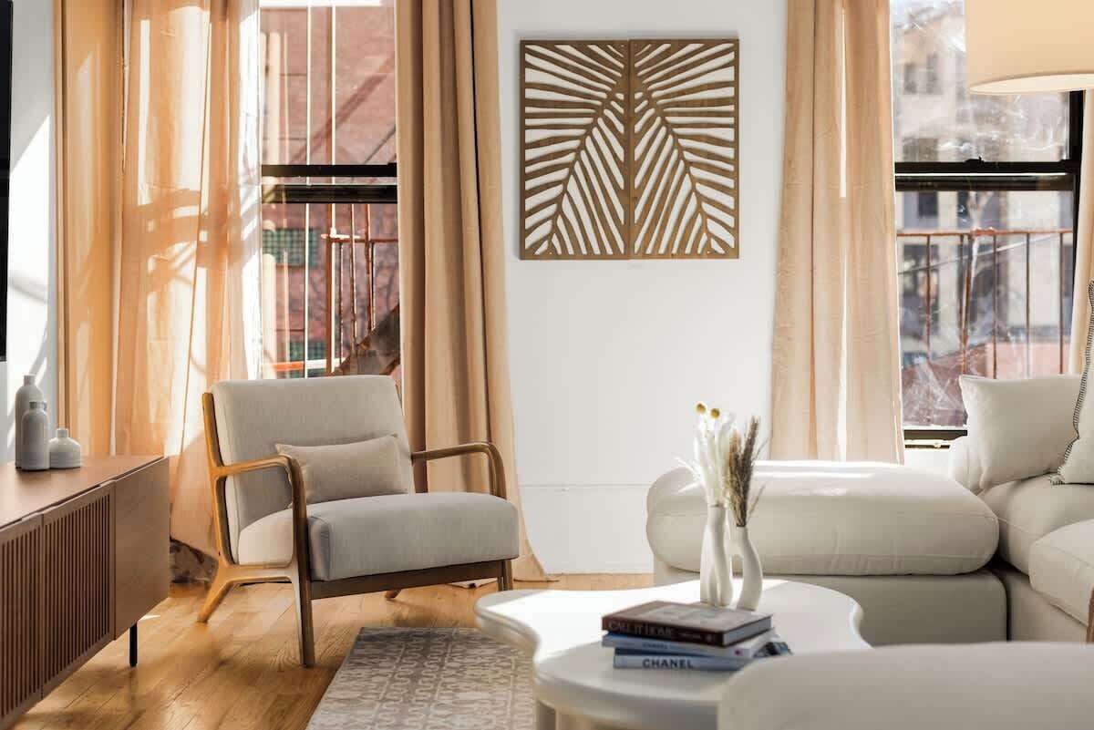 Un soggiorno moderno con divano, poltrona e un elemento decorativo a parete.