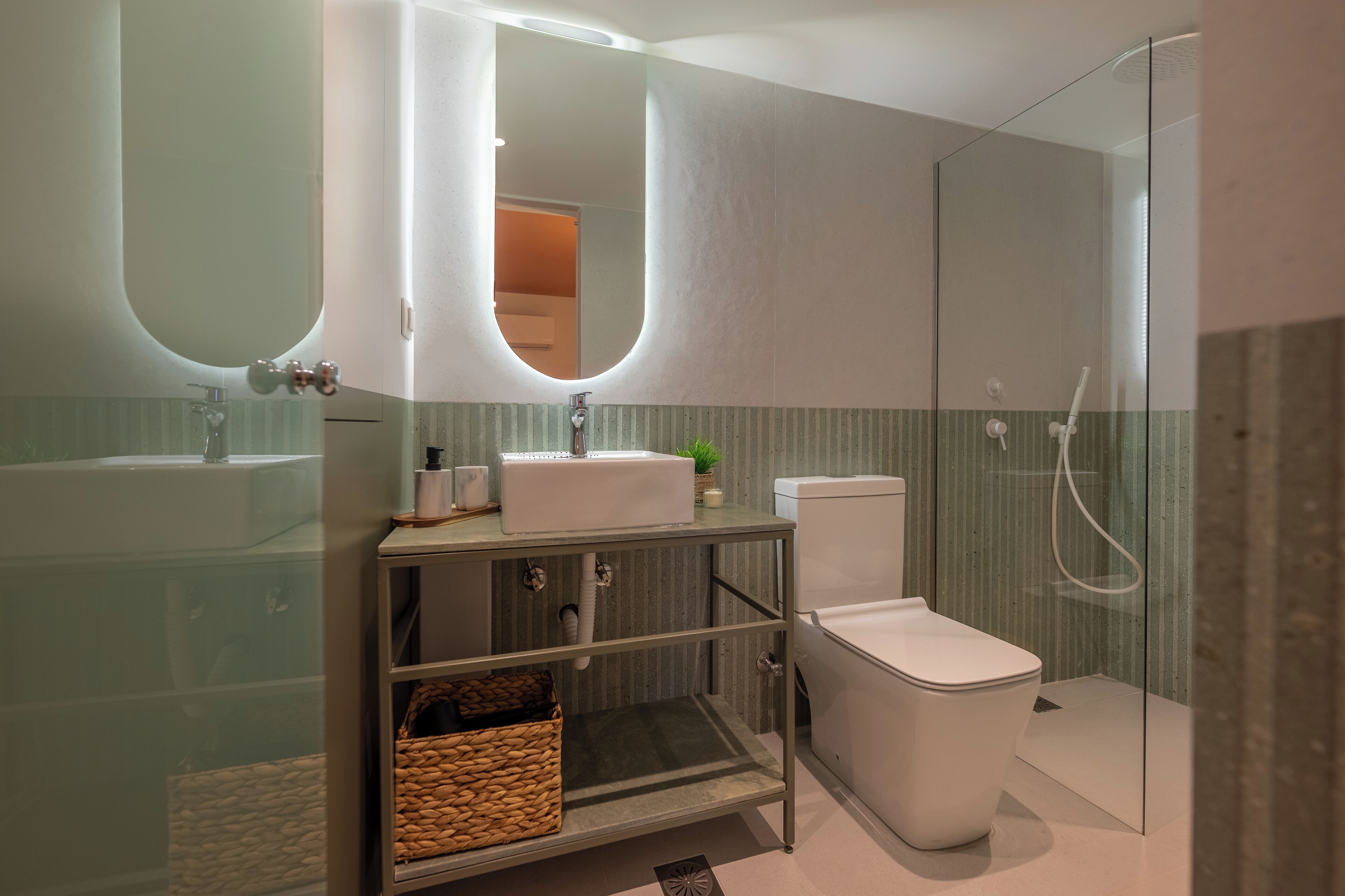 A modern bathroom with a glass-enclosed shower, a white sink, and a toilet.