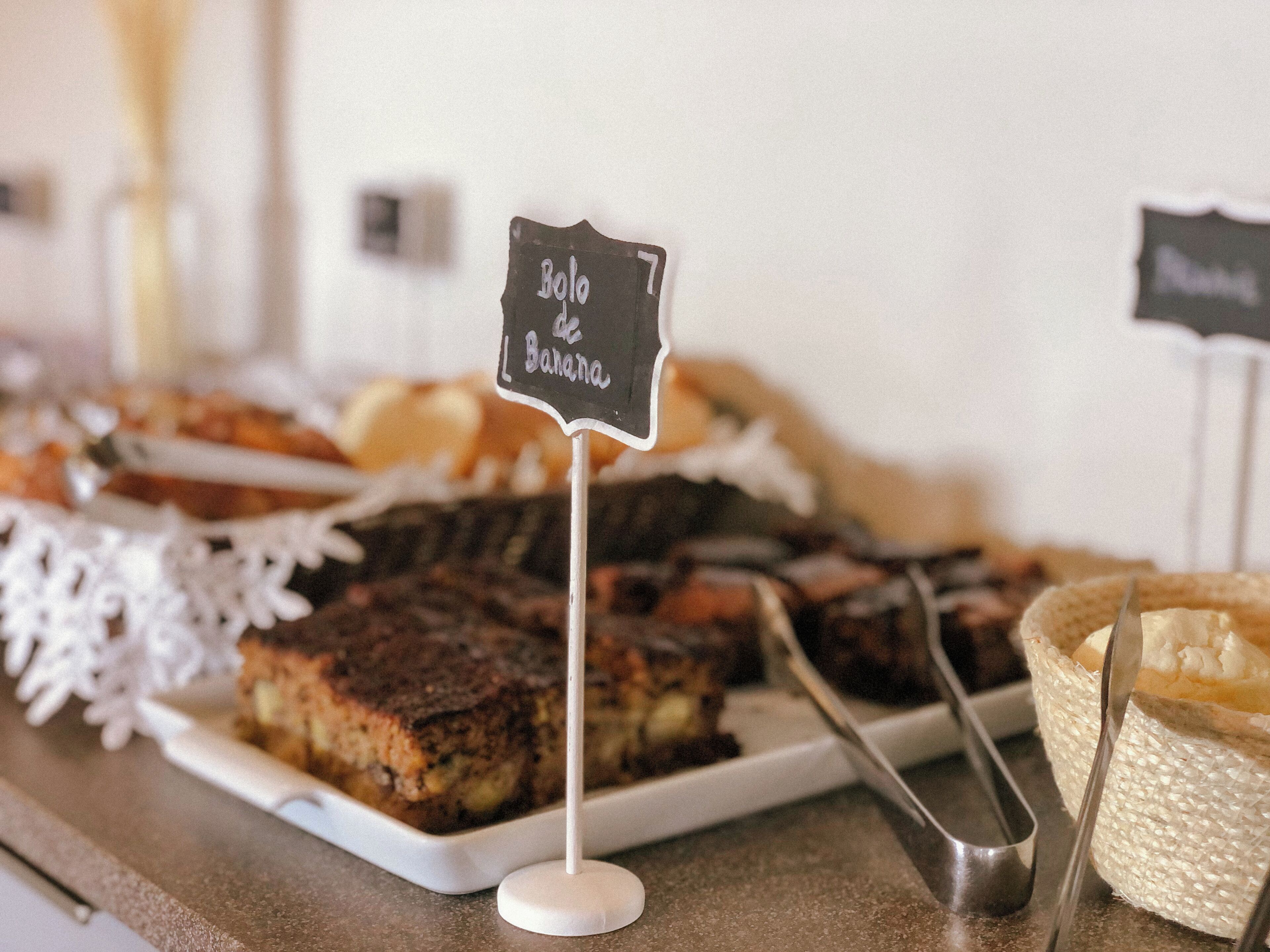 Una mesa de buffet con diversas opciones de panadería, incluyendo pan de plátano y otros postres.