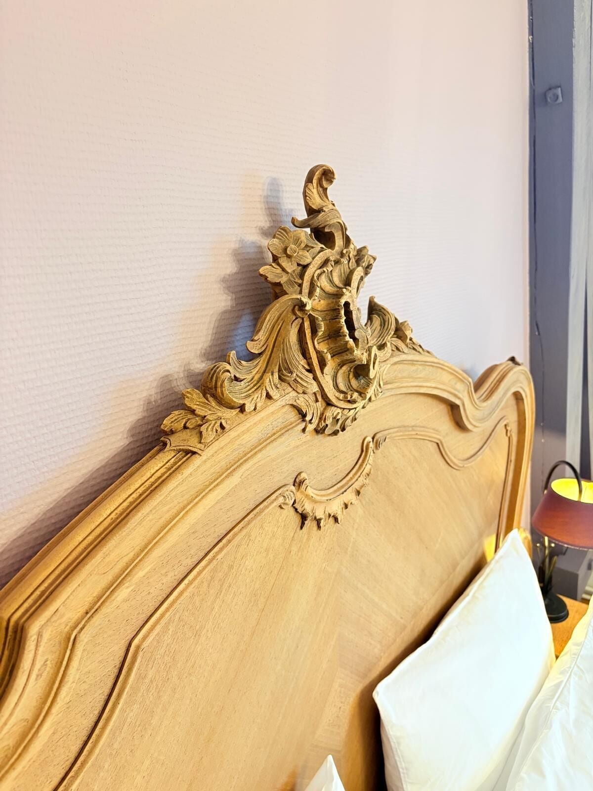A wooden headboard with intricate carvings and a white pillow.