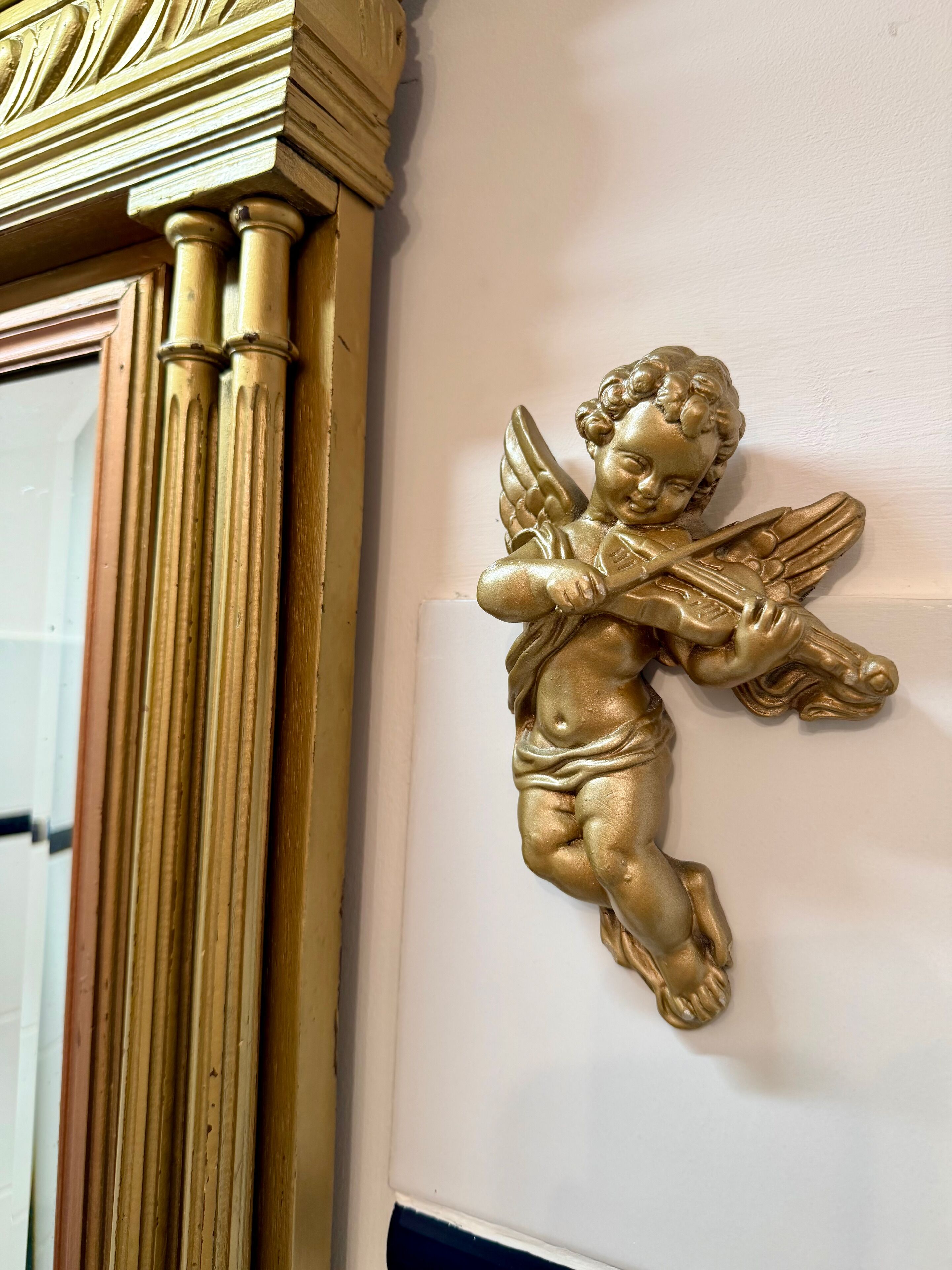 Een gouden engelbeeld op een muur.
