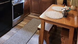 A kitchen with wooden cabinets, a stove, a microwave, and a sink. - Cozy Sugar Pine Cottage (Vowinckel)