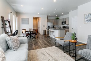 A modern kitchen with a refrigerator, microwave, and sink.