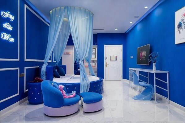 A room with a canopy bed, blue seating, a vanity, and a TV. - Sanya Fenglinwan Hotel (Sanya)