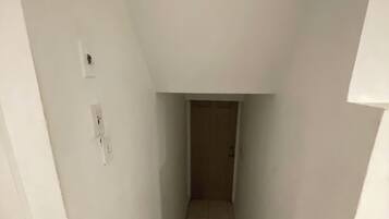 Een smalle trap die naar een deur aan de bovenkant leidt.