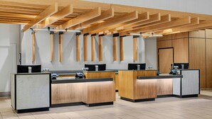 Een receptie met houten balies, een modern plafondontwerp en een strakke, minimalistische uitstraling.
