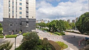 Un bâtiment moderne doté d’un toit plat et d’un grand espace de stationnement à l’avant.
