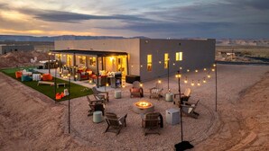 Una casa moderna con patio, mobiliario exterior y una chimenea.