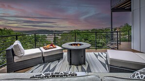 A balcony with outdoor seating, a fire pit, and a scenic view of the landscape. - NEW LISTING! Stunning Lakehouse with Views, Hot Tub & Game Room! (Lago Vista)