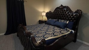 A bedroom with a dark wood four-poster bed, a ceiling fan, and a nightstand with a lamp. - Gates at Sour Lake #502 (Sour Lake)