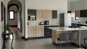 Eine moderne Küche mit einer zentralen Kochinsel, Holzschränken und einem eingebauten Backofen.