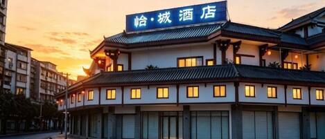 A hotel with a traditional architectural style, multiple floors, and a sign indicating its name.