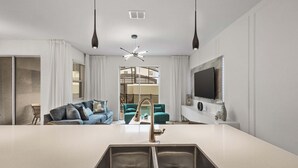 A modern kitchen with a central island, a built-in sink, and a ceiling fan. - Stylish Family Retreat With Themed Bedrooms (Kissimmee)