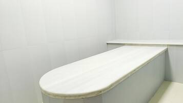 Un rincón de un baño con un inodoro y un lavamanos blancos.