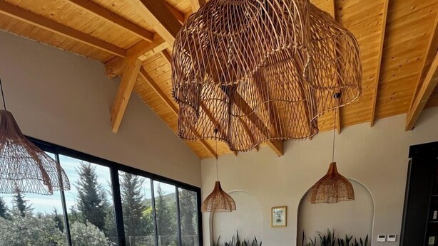 Un'ampia sala da pranzo con soffitto alto, ampie finestre e vista sull'esterno.
