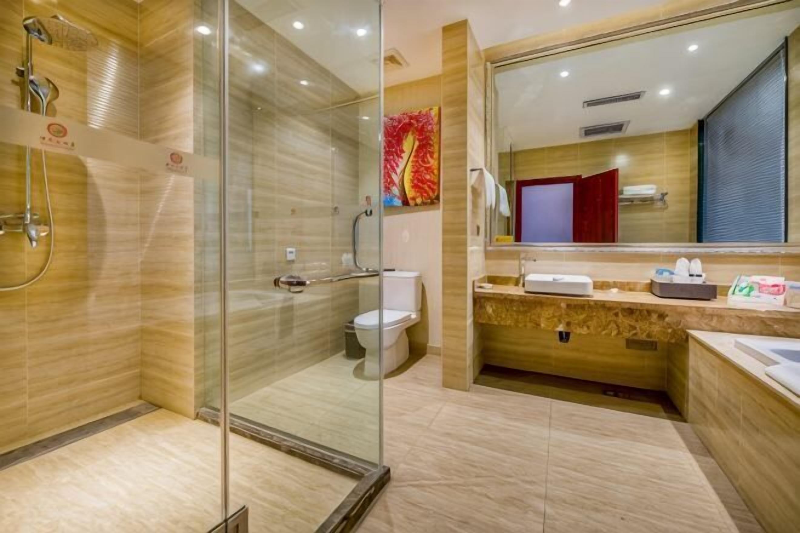 A modern bathroom with a glass shower enclosure, a toilet, and a vanity with a mirror.