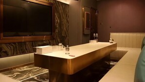 A modern bathroom with a marble vanity, a large mirror, and a seating area. - Minghua Hotel (Aksu Tianbai Fashion Shopping Center Xinglong Underground Street Branch) (Aksu City)