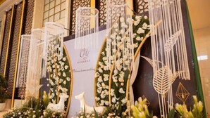 A decorative display with floral arrangements and a sign that reads "Please come wedding." - Minghua Hotel (Aksu Tianbai Fashion Shopping Center Xinglong Underground Street Branch) (Aksu City)