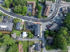 An aerial view of a residential area with houses, a parking lot, and a road.