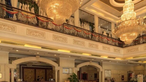 A grand lobby with chandeliers, a reception desk, and a staircase. - Hengsheng Hotel (Baise)