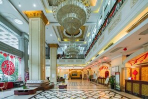 A spacious lobby with a high ceiling, ornate chandeliers, and a central seating area. - Hengsheng Hotel (Baise)
