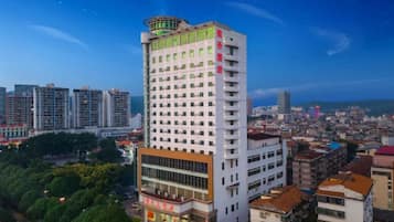 Un hotel de gran altura con varios pisos, una estructura destacada en la azotea y un entorno urbano circundante.
