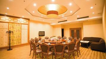 A conference room with a round table, chairs, and a television.