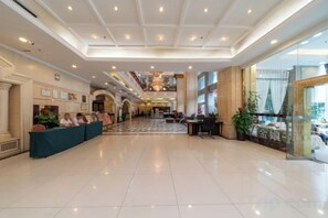 A spacious lobby with a reception desk, seating area, and a view of the upper floor. - Hengsheng Hotel (Baise)