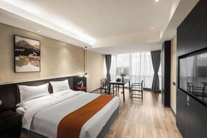 Una habitación de hotel moderna con una cama grande, un escritorio y un comedor.