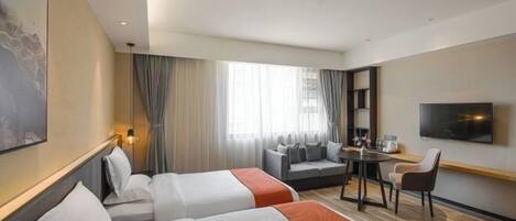 Habitación de hotel con dos camas, un sofá, una mesita, un televisor y un amplio ventanal con cortinas.
