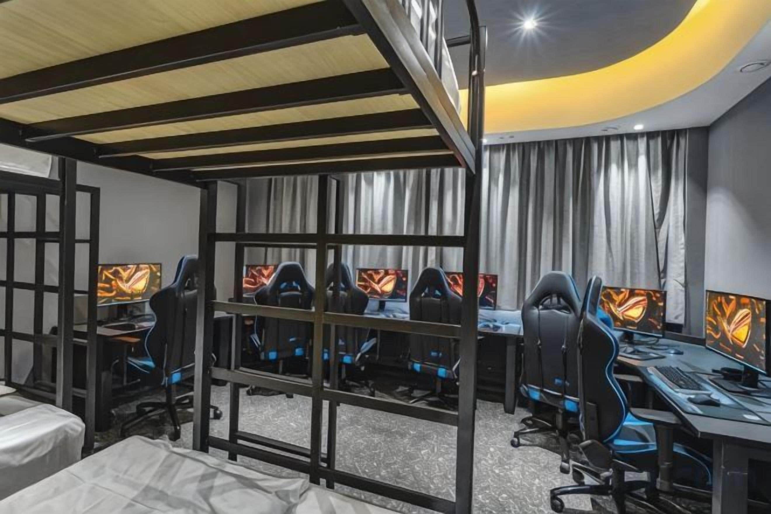 A gaming room with multiple gaming stations, each with a monitor and a chair.