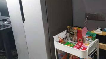 A white metal cart with various items including a red bag, a green box, and a white container.