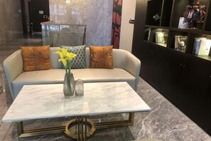A modern lobby with a sofa, a vase with flowers, and a marble table. - Hengtai Hotel (Zhengzhou Zijingshan Street Subway Station) (Zhengzhou)