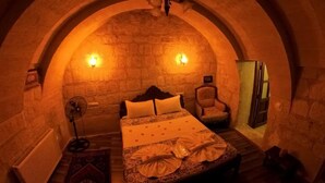 A cozy, arched room with a bed, a chair, and a fan. - Bellavista Stone House (Urgup)
