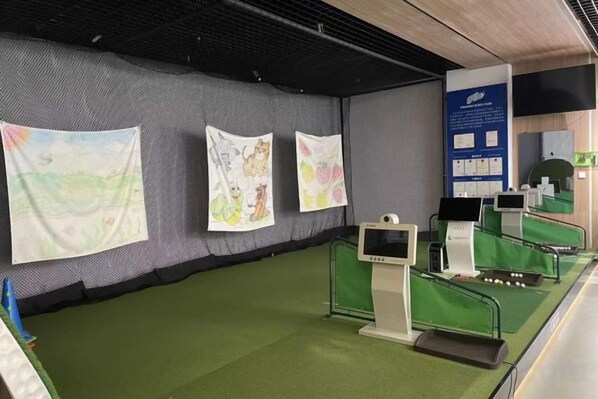A room with green carpeting, a wall-mounted screen, and a desk with a computer. - GELI Hotel (Hongqiao Airport Wuzhong Road) (Shanghai)