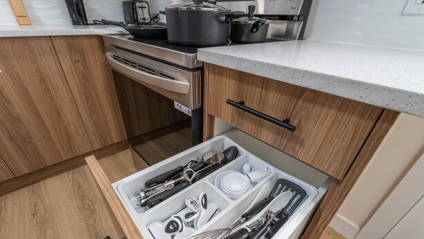 Une cuisine avec des meubles en bois, une cuisinière en acier inoxydable et un plan de travail.