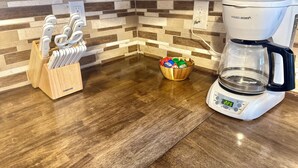 A kitchen with a coffee maker, knife block, and a bowl of colorful cups. - Comfortable and Spacious Home close to OSU Campus (Stillwater)