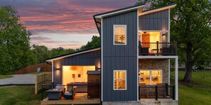 Une maison à deux étages avec un balcon, une terrasse et un garage.