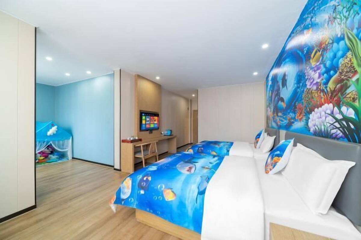A hotel room with a bed, a desk, and a TV.