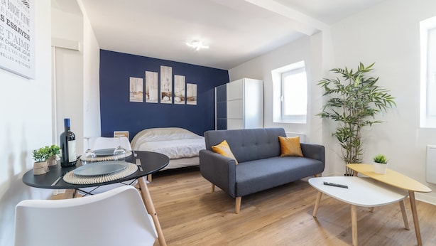 A modern living room with a sofa, a dining table, and a bed. - The Sweet yachtsman (Mulhouse)