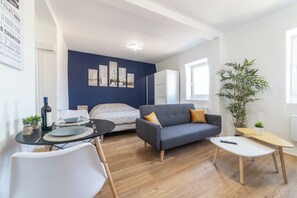 Ein modernes Wohnzimmer mit einer Couch, einem Esstisch und einem Bett.