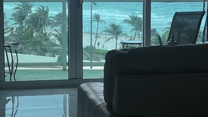 A room with a large window overlooking a beach and ocean. - Chic and modern 1-bedroom apartment with 0cean view, WiFi in vibrant Hollywood (Hollywood)