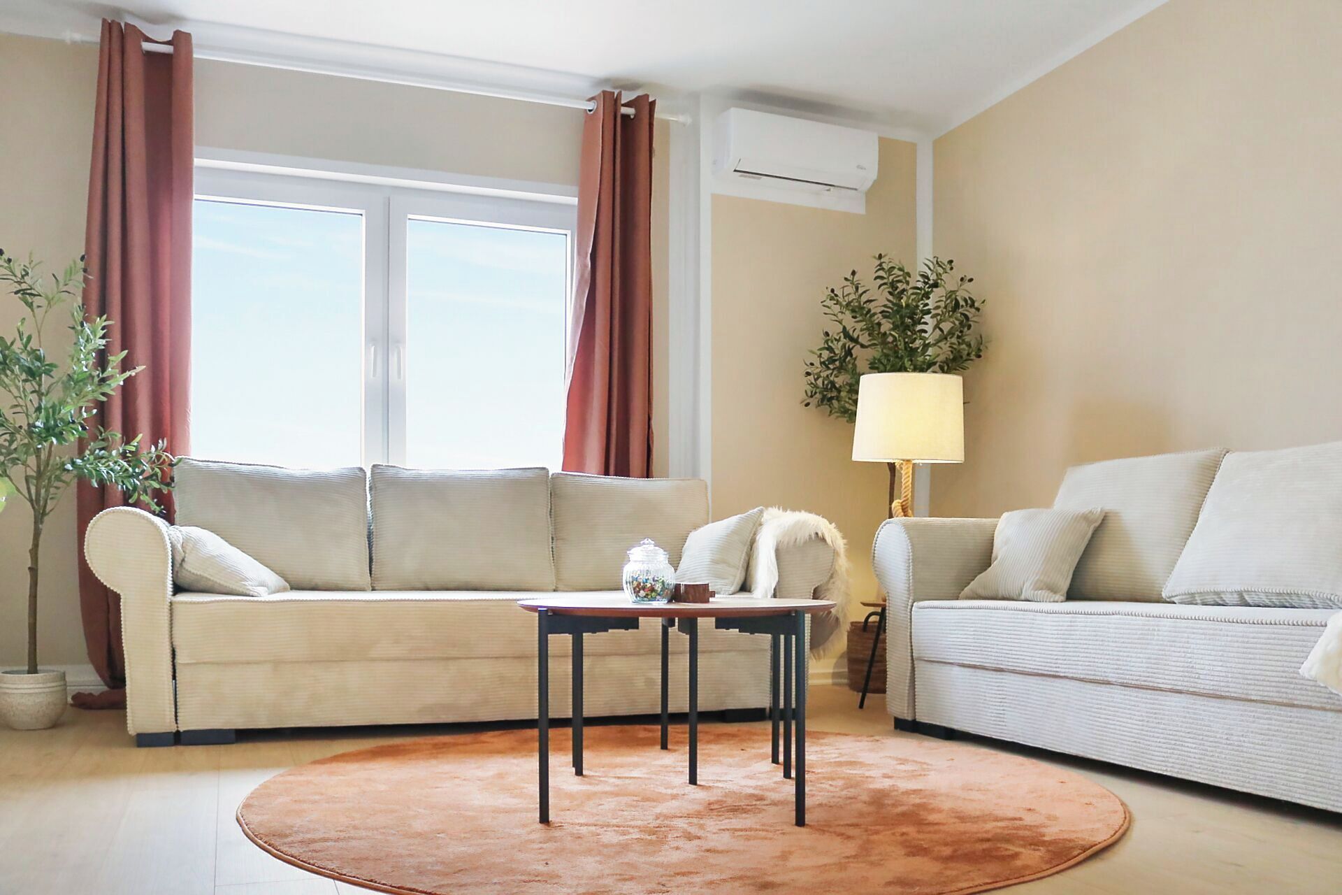 A living room with two sofas, a coffee table, a lamp, and a potted plant.