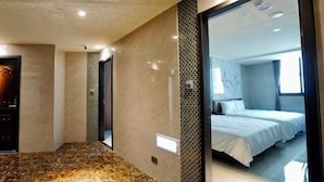 A modern hotel room with a marble floor, a large mirror reflecting the room, and a bed with white linens. - Dragon River Hotel (Nantou)