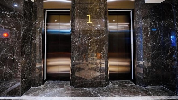 A marble-floored lobby with two elevators, each marked with a number. - Dragon River Hotel (Nantou)